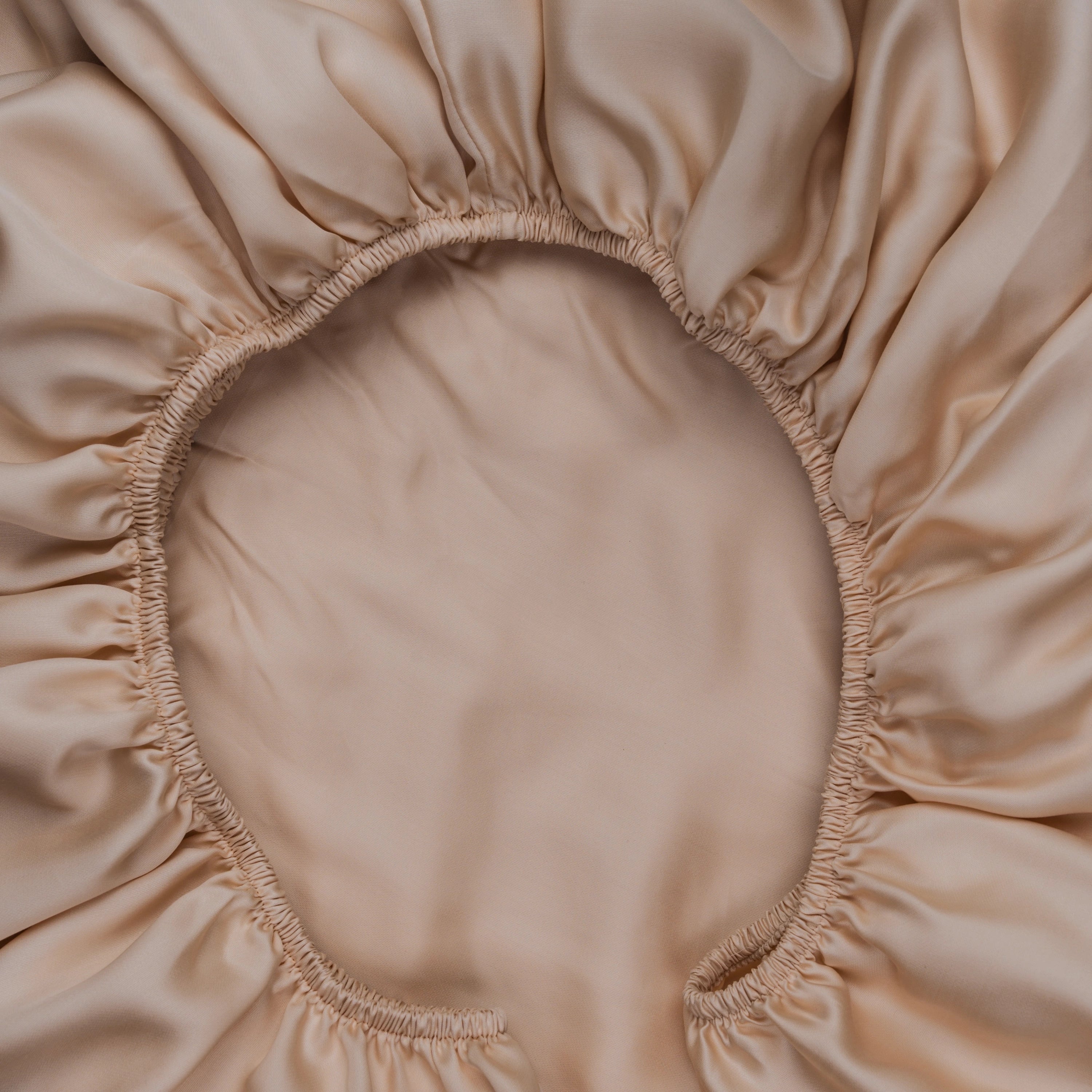 Beigefarbenes Spannbettlaken aus Micro TENCEL™ Lyocell, Detailansicht mit Rundumgummi, seidig-glatt und temperaturregulierend