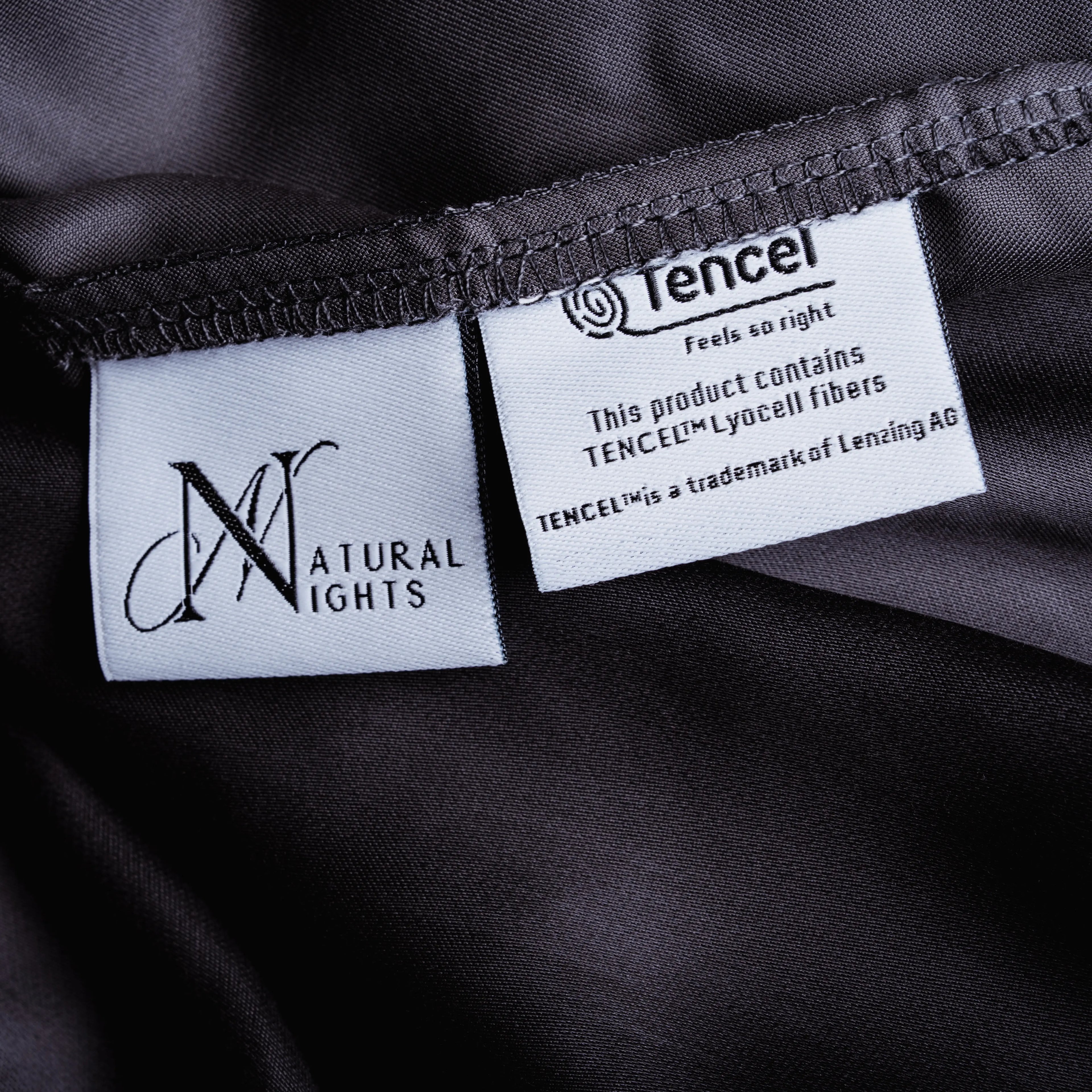 Dunkelgraues Spannbettlaken aus Micro TENCEL™ Lyocell mit eingewebtem Natural Nights Label und TENCEL™ Markenetikett, Detailansicht