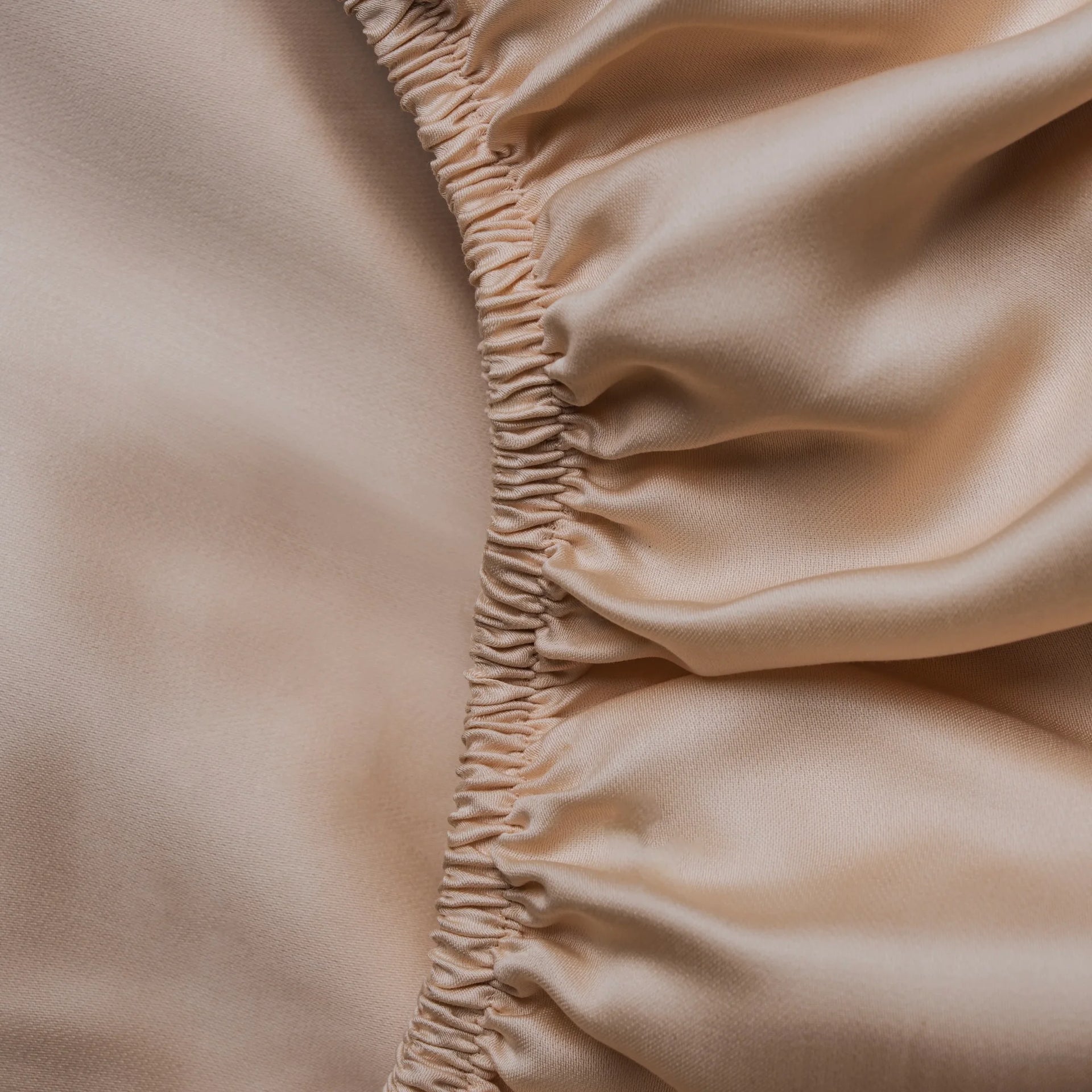 Beiges Spannbettlaken aus Micro TENCEL™ Lyocell „Shell Dune“, Detailansicht mit Rundumgummi, seidig-glatt und temperaturregulierend für luxuriösen Schlafkomfort