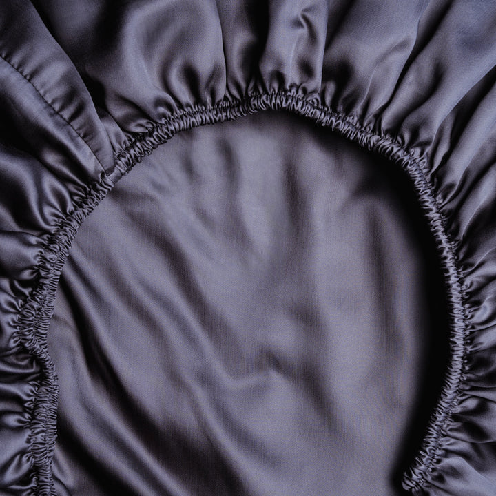 Dunkelgraues Spannbettlaken aus Micro TENCEL™ Lyocell, Detailansicht mit Rundumgummi, seidig-glatt und temperaturregulierend