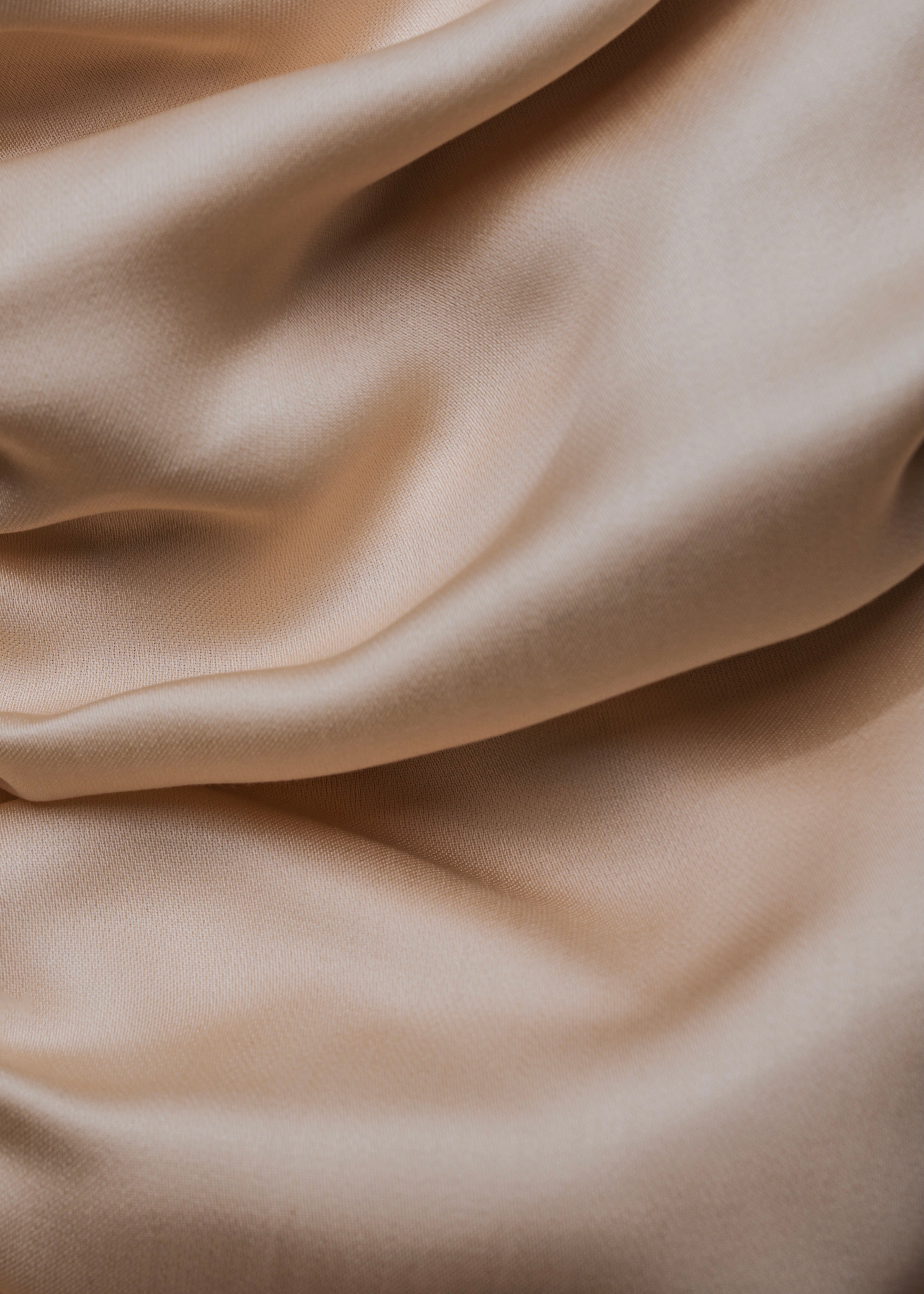 Nahaufnahme eines beigen Tencel-Spannbettlakens von Natural Nights mit luxuriöser, glatter Struktur